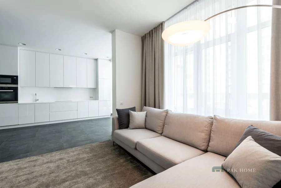 Sheer curtains hanging in even folds across a bright open-plan living room