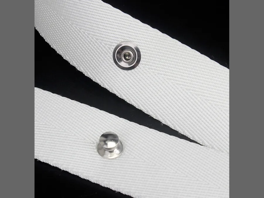 Close-up of white curtain heading tape with a metal press stud