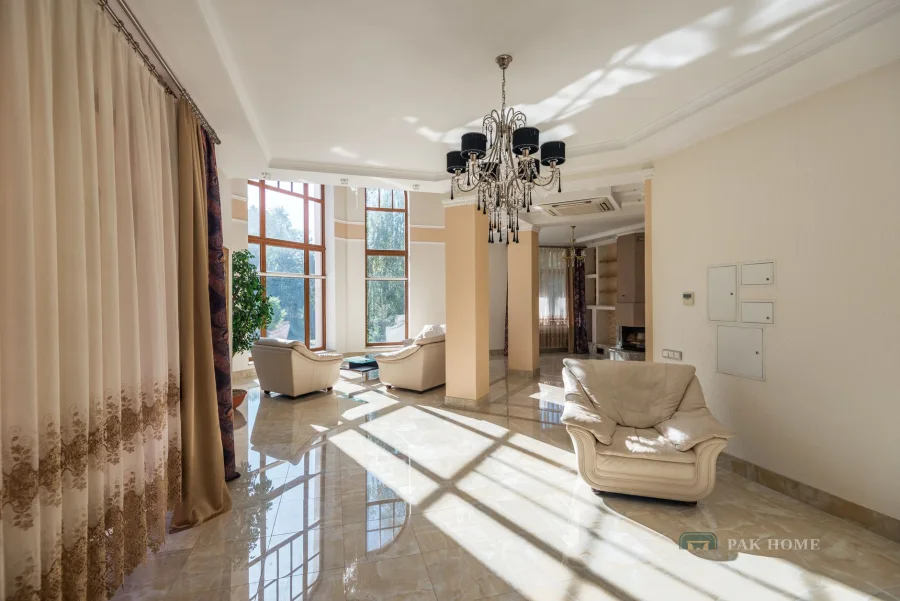 Full-height curtains across tall villa windows in a bright reception room